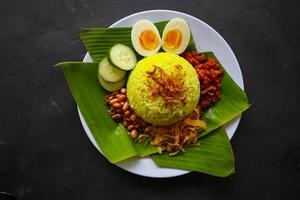 nasi kuning o arroz amarillo o arroz tumeric es comida tradicional de asia, hecho arroz cocinado con cúrcuma, leche de coco r foto