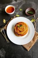 paratha bread or canai bread or roti maryam, favorite breakfast dish. served on plate photo