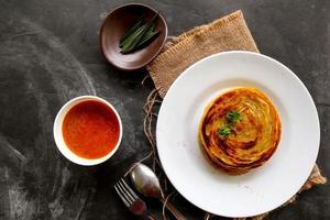 paratha bread or canai bread or roti maryam, favorite breakfast dish. served on plate photo