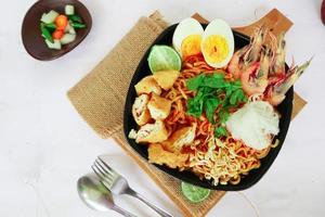 laksa, laksa curry made from vermicelli, noodles, bean sprouts, egg, tofu lime, and shrimp with a spicy soup sauce that is rich in spices. laksa served on bowl, isolated on white background. photo