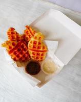 Croissant Waffle or Croffle with chocolate sauce served in box and white background photo