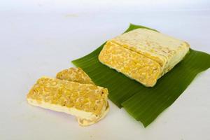 Raw tempeh or tempe. tempeh slices in white background. raw soybean seeds. Tempe is a traditional Indonesian food made from fermented soybeans. photo