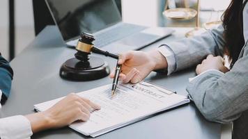 Justice and law concept.Male judge in a courtroom with the gavel, working with, computer and docking keyboard, eyeglasses, on table in morning light video