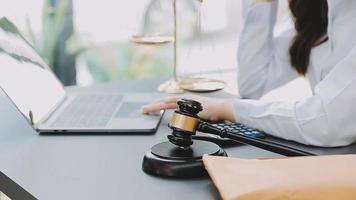 Justice and law concept.Male judge in a courtroom with the gavel, working with, computer and docking keyboard, eyeglasses, on table in morning light video