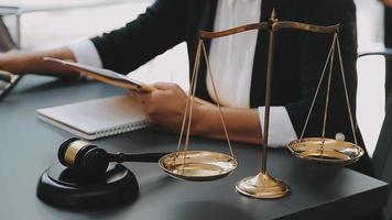 law books and scales of justice on desk in library of law firm. jurisprudence legal education concept. video