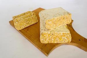 Raw tempeh or tempe. tempeh slices in white background. raw soybean seeds. Tempe is a traditional Indonesian food made from fermented soybeans. photo