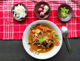 Goat Curry or gulai kambing, food from asia. Delicious goat meat curry served in a bowl.served with tomato, seasoning, celery and cabbage photo