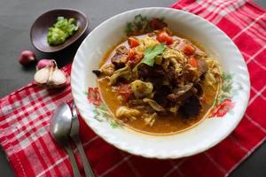 Goat Curry or gulai kambing, food from asia. Delicious goat meat curry served in a bowl.served with tomato, seasoning, celery and cabbage photo