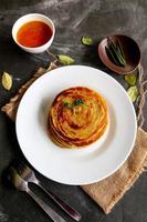 paratha bread or canai bread or roti maryam, favorite breakfast dish. served on plate photo