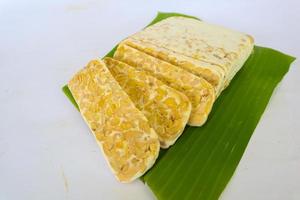 Raw tempeh or tempe. tempeh slices in white background. raw soybean seeds. Tempe is a traditional Indonesian food made from fermented soybeans. photo