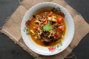 Goat Curry or gulai kambing, food from asia. Delicious goat meat curry served in a bowl.served with tomato, seasoning, celery and cabbage photo