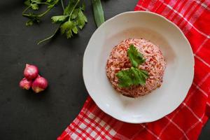 Red steamed rice or nasi merah served in plate isolated on black background photo