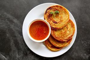 paratha bread or canai bread or roti maryam, favorite breakfast dish. served on plate photo