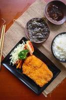 chicken katsu don is japanese food served with soy sauce on table photo