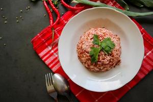 Red steamed rice or nasi merah served in plate isolated on black background photo