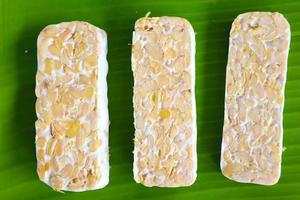 Raw tempeh or tempe. tempeh slices in white background. raw soybean seeds. Tempe is a traditional Indonesian food made from fermented soybeans. photo