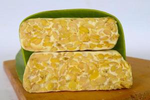 Raw tempeh or tempe. tempeh slices in white background. raw soybean seeds. Tempe is a traditional Indonesian food made from fermented soybeans. photo