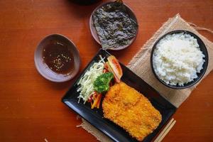 chicken katsu don is japanese food served with soy sauce on table photo