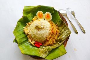 Nasi Liwet Solo or Sego Liwet Solo is a traditional food from Surakarta. made from savory rice, chayote and boiled egg, chicken, thick coconut milk served on a banana leaf photo