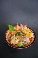 laksa, laksa curry made from vermicelli, noodles, bean sprouts, egg, tofu lime, and shrimp with a spicy soup sauce that is rich in spices. laksa served on bowl, isolated on white background. photo