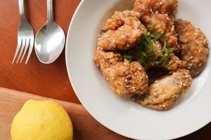 Delicious homemade crispy fried chicken with spicy taste and lemon on plate photo