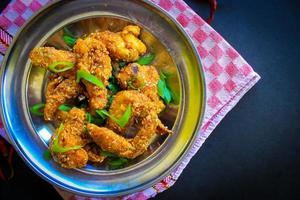 Delicious homemade crispy fried chicken with spicy taste and lemon on plate photo