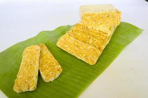 Raw tempeh or tempe. tempeh slices in white background. raw soybean seeds. Tempe is a traditional Indonesian food made from fermented soybeans. photo