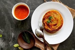 paratha bread or canai bread or roti maryam, favorite breakfast dish. served on plate photo