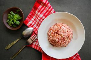 Red steamed rice or nasi merah served in plate isolated on black background photo