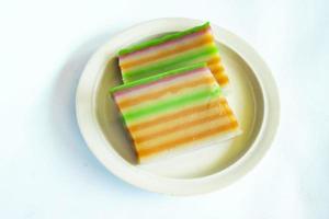 lapis cake or roti lapis or layer cake or lapis legit served in little plate isolated on white background made from rice flour, starch, coconut milk, sugar, salt and coloring photo