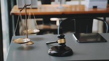 law books and scales of justice on desk in library of law firm. jurisprudence legal education concept. video