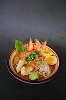 laksa, laksa curry made from vermicelli, noodles, bean sprouts, egg, tofu lime, and shrimp with a spicy soup sauce that is rich in spices. laksa served on bowl, isolated on white background. photo