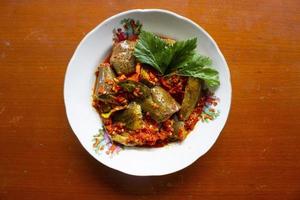 sambal terong or eggplant sauce is Indonesian traditional food chili sauce, made from chilies and eggplants are crushed and then fried isolated on black background photo