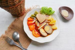 selat solo is traditional salad food from indonesia. made from hard-boiled eggs, boiled chickpeas, boiled carrots, hash browns and lettuce, steak or bistik. served on wood table photo