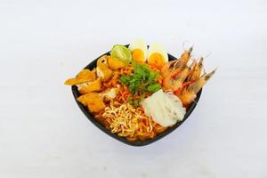 laksa, laksa curry made from vermicelli, noodles, bean sprouts, egg, tofu lime, and shrimp with a spicy soup sauce that is rich in spices. laksa served on bowl, isolated on white background. photo
