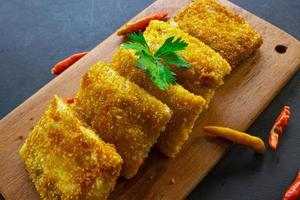 Fried Risoles or Risol Mayo are Indonesian snacks. Like Coxinha de Galinha. served with chili sauce, celery on wood board photo