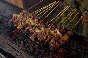 sate kambing or satay goat, lamb, Lamb or meat goat satay with charcoal ingredient on red fire grilling by people. traditional satay from yogyakarta, java, Indonesia cooking satay photo