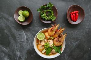 Tom yam soup originating from Thailand. Tom yum is made with shrimp, chili, lime, chicken, fish, or seafood and mushrooms. photo