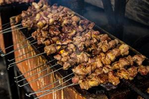 sate klatak or sate kambing or satay goat, lamb, Lamb or meat goat satay with charcoal ingredient on red fire grilling by people, Indonesia cooking satay. with selective focus photo