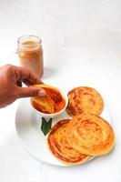 roti canai and teh tarik. paratha bread or canai bread or roti maryam, favorite breakfast dish. served on plate photo