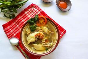 Chicken soup served with vegetables, tomatoes, celery in a bowl, spoon and fork. with black background photo