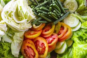 a mixture of healthy salad, vegetables, fresh cucumbers, cabbage, tomatoes, long beans or Yardlong bean, Diet menu. Top view., flat lay photo