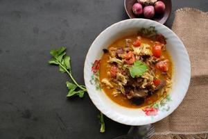 Goat Curry or gulai kambing, food from asia. Delicious goat meat curry served in a bowl.served with tomato, seasoning, celery and cabbage photo