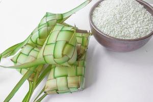 ketupat en plato de barro aislado sobre fondo blanco. la bola de masa de arroz ketupat es un alimento que se sirve cuando idhul fitri eid mubarak en indonesia, hecho de arroz envuelto en hojas de coco tiernas janur foto