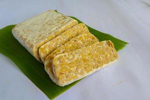 Raw tempeh or tempe. tempeh slices in white background. raw soybean seeds. Tempe is a traditional Indonesian food made from fermented soybeans. photo