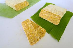 Raw tempeh or tempe. tempeh slices in white background. raw soybean seeds. Tempe is a traditional Indonesian food made from fermented soybeans. photo