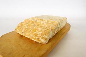 Raw tempeh or tempe. tempeh slices in white background. raw soybean seeds. Tempe is a traditional Indonesian food made from fermented soybeans. photo