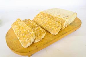 Raw tempeh or tempe. tempeh slices in white background. raw soybean seeds. Tempe is a traditional Indonesian food made from fermented soybeans. photo