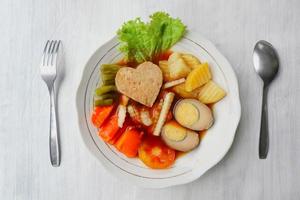 selat solo is traditional salad food from indonesia. made from hard-boiled eggs, boiled chickpeas, boiled carrots, hash browns and lettuce, steak or bistik. served on wood table photo