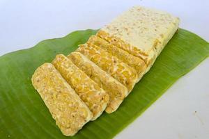 Raw tempeh or tempe. tempeh slices in white background. raw soybean seeds. Tempe is a traditional Indonesian food made from fermented soybeans. photo